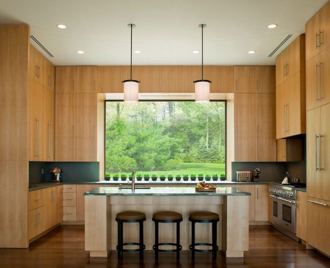 Высокий кухонный гарнитур из светлого ясеня сделает комнату визуально выше 