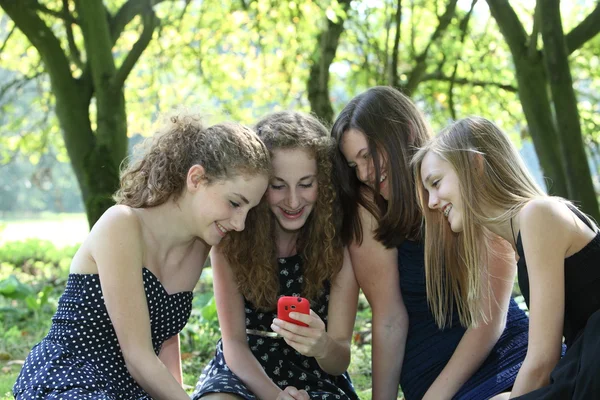 Группа happy подростков чтение sms — стоковое фото