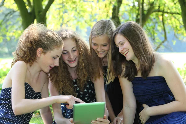 Группа из четырех привлекательной молодой подросток, работы с планшетным компьютером — стоковое фото