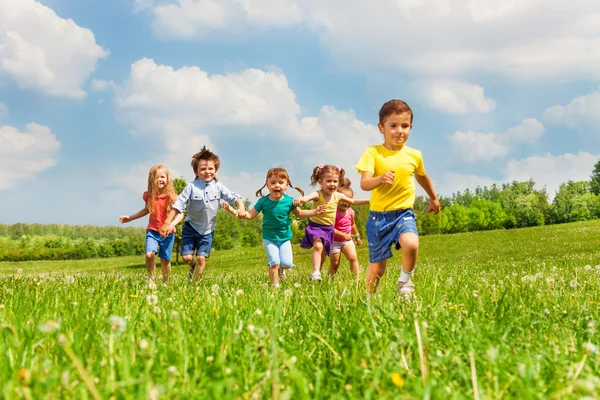 Запуск дети в зеленом поле летом — стоковое фото