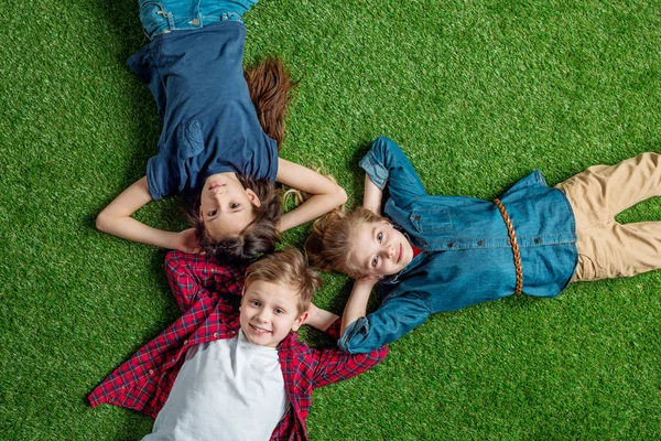 Дети лежат на траве — стоковое фото