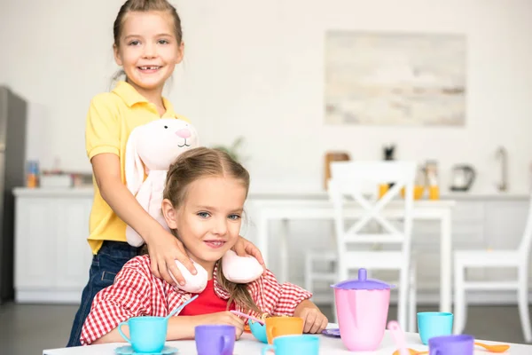 Little Smiling Sisters Pretending Have Tea Party Together Home — стоковое фото